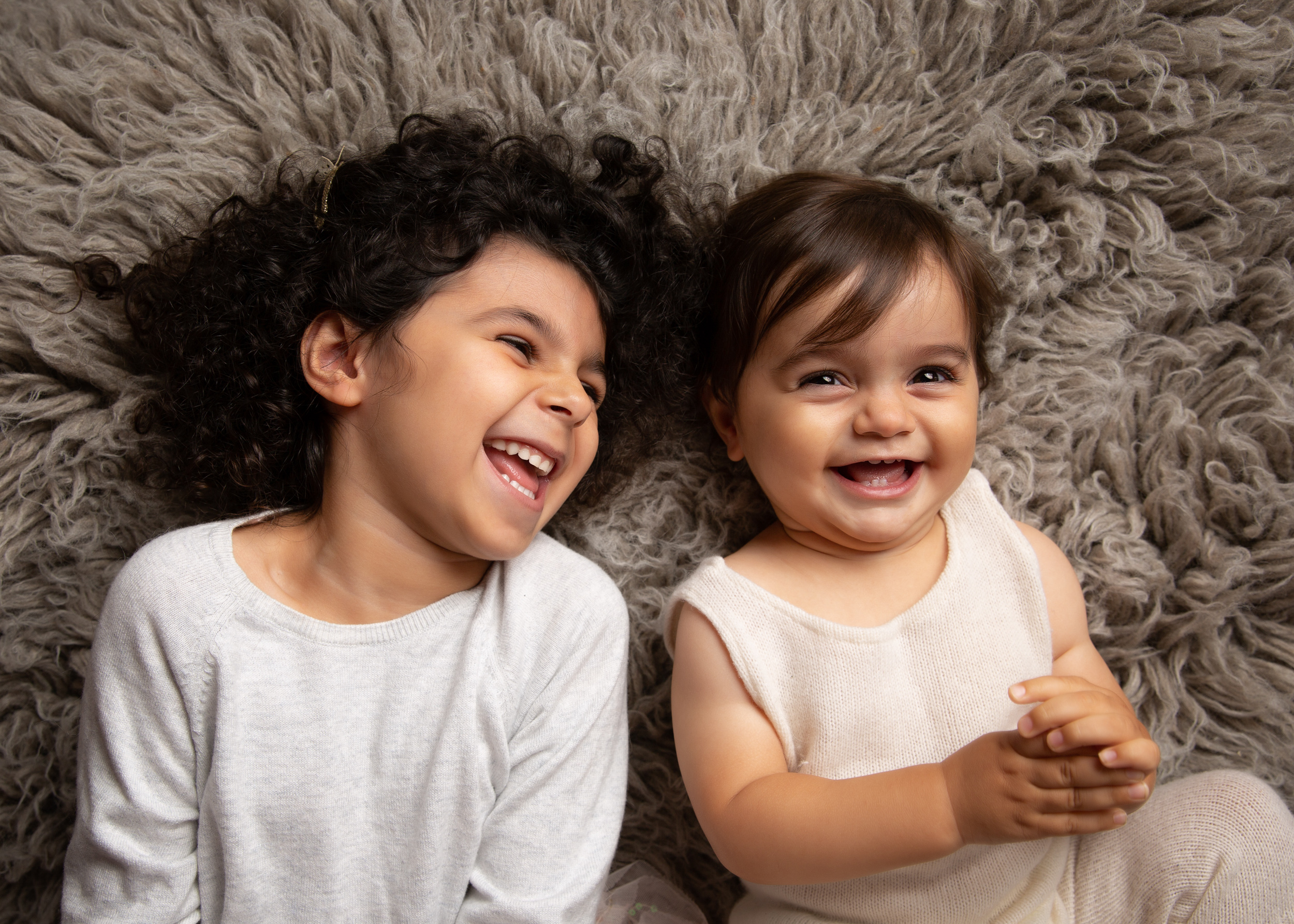 Siblings laughing together during their photo shoot in Cheshire