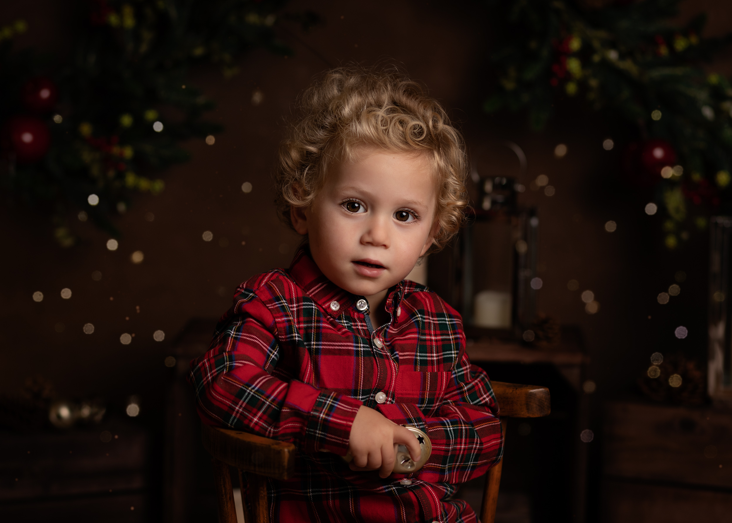 A little boy in a red shirt posing for his Christmas Mini Session photo shoot in Cheshire