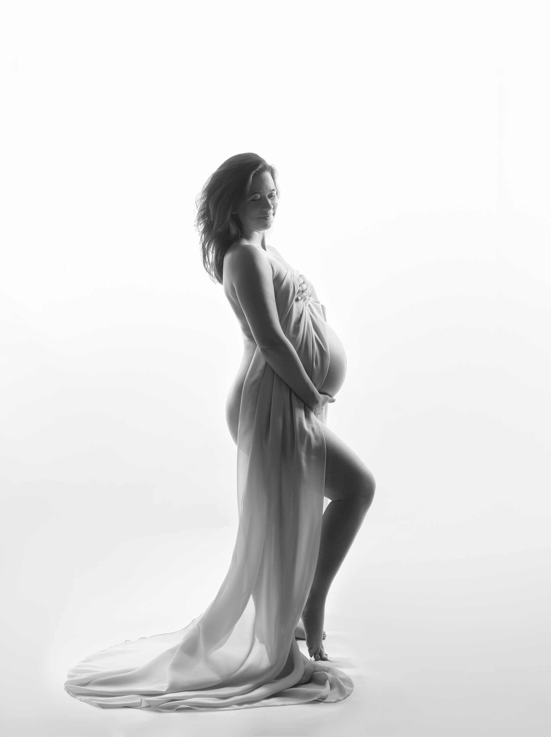 Beautiful back-lit pregnant lady showing off her bump in Cheshire