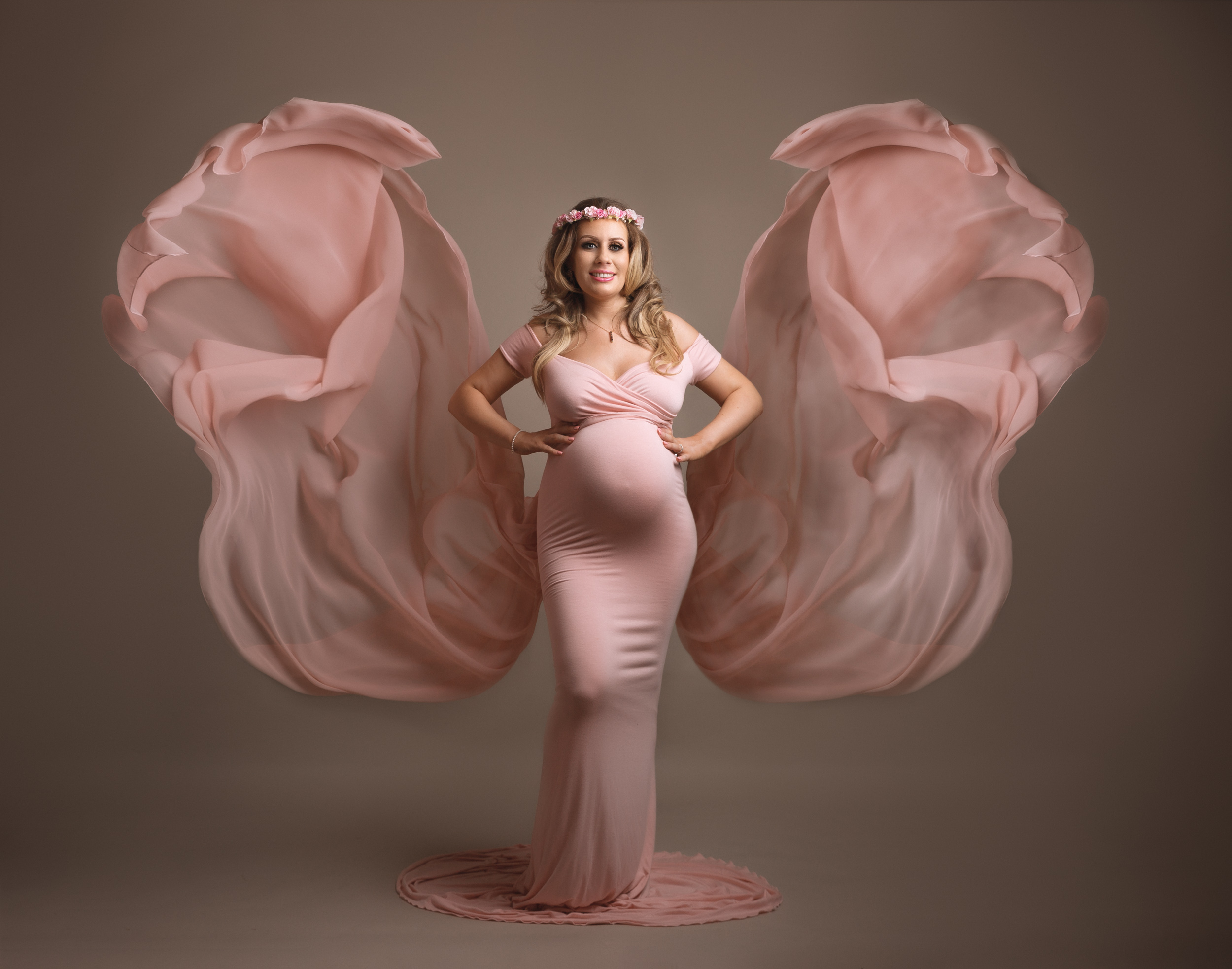 Pregnant lady in a floating pink dress that looks like butterfly wings at her bump shoot in Sandbach, Cheshire