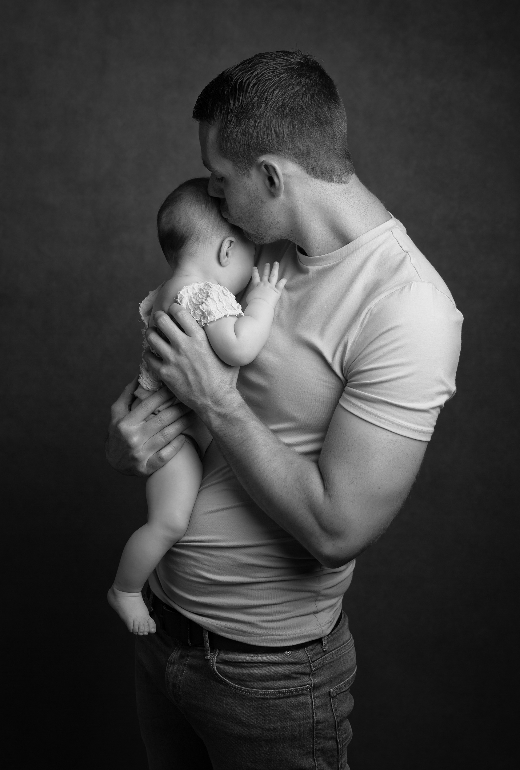 Daddy and baby having a cuddle taken during a milestone portrait session in Sandbach, Cheshire