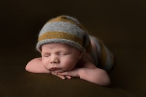 Posed newborn with a dark green colour scheme by Cheshire newborn photographer in Sandbach