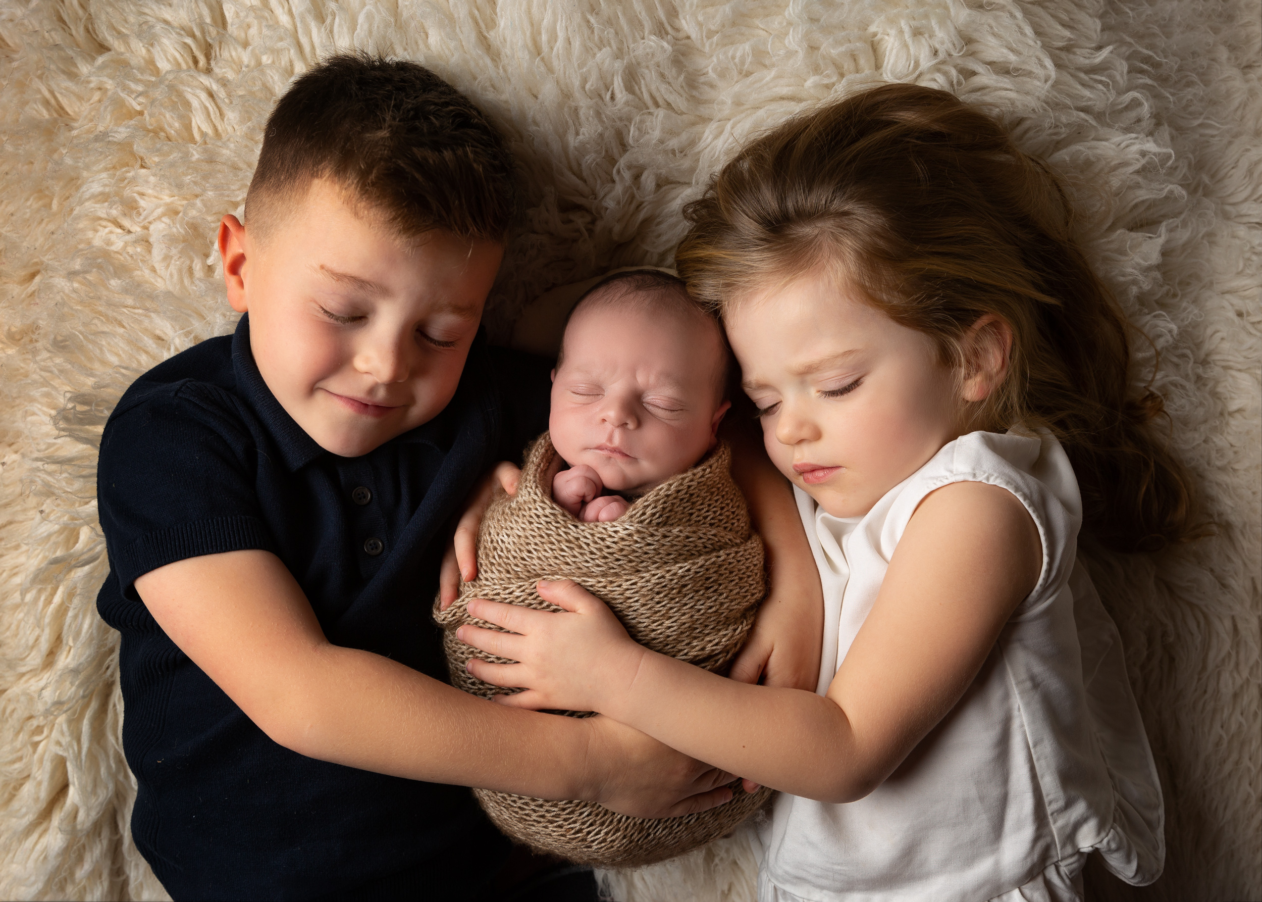 Sibling shot with their baby brother by Cheshire newborn photographer in Sandbach