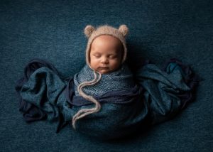 10 week old baby with blue colour scheme and bear bonnet by Cheshire newborn photographer in Sandbach