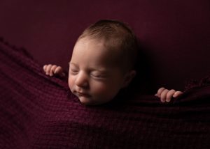 Dark and moody newborn photo of asleep baby by Cheshire newborn photographer in Sandbach
