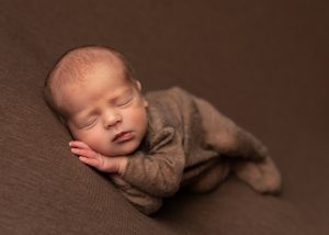 side posed newborn baby all in brown by Cheshire newborn photographer in Sandbach