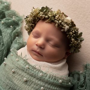 newborn baby wrapped in cream and green with pearls and halo by Cheshire newborn photographer in Sandbach