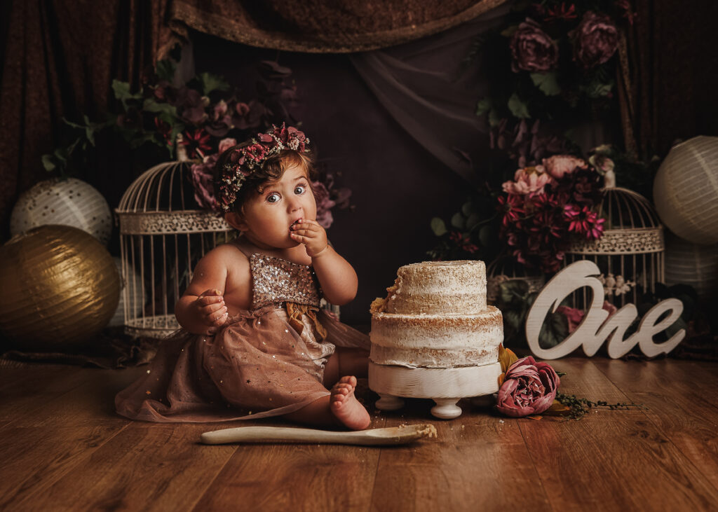 Elegant and artistic cake smash setup for beautiful little girl. She is eating cake in my Sandbach Photography Studio.