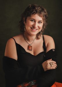 Self portrait of Newborn Photographer Lisa Sumner on dark background