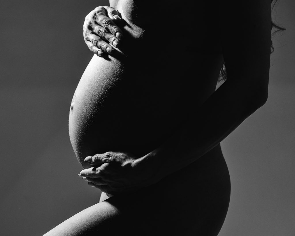 Black and white pregnant bump photo showcasing details with high contrast taken in my maternity photography studio in Sandbach.